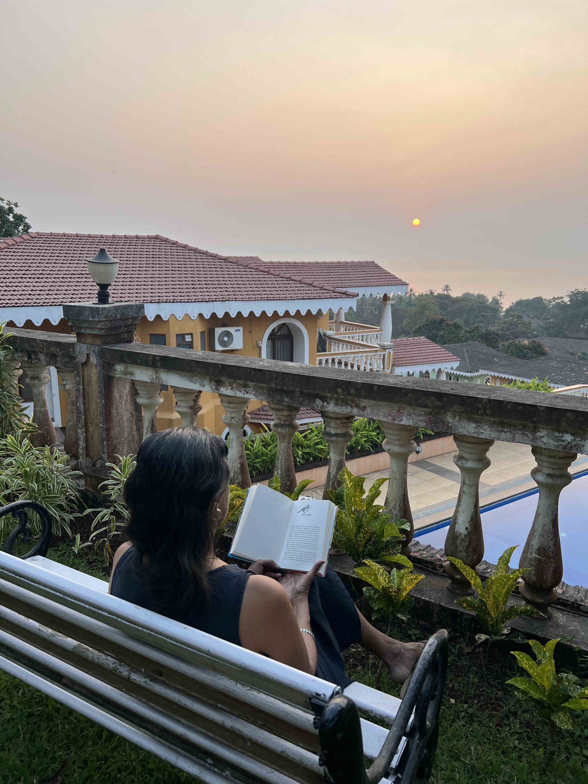Reading at sunset woman on bench reading a book with sunset in the background